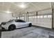 Spacious three car garage with a modern gray car, high ceilings, and ample lighting at 1334 Sunnybrook Ln, Greenwood, IN 46143