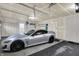 Well-organized garage featuring a modern gray car, rubber floor mat and good lighting at 1334 Sunnybrook Ln, Greenwood, IN 46143
