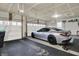 Organized three car garage showing black rubber floor mat, overhead lighting, and door openers at 1334 Sunnybrook Ln, Greenwood, IN 46143