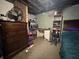 Unfinished basement featuring a dresser, computer, shelving and bed at 144 S 7Th Ave, Beech Grove, IN 46107
