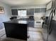 Well lit kitchen features a central island, gray cabinets and modern appliances at 144 S 7Th Ave, Beech Grove, IN 46107