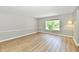 Minimalist bedroom with wood flooring, neutral colors, and a bright window overlooking a green space at 16857 Palmetto Way, Noblesville, IN 46062