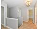 Bright upstairs hallway with wood floors, white trim and baseboards and a decorative chandelier at 16857 Palmetto Way, Noblesville, IN 46062