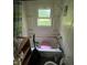 Bathroom with shower head and open window with shelving on the side at 1801 E 16Th St, Muncie, IN 47302