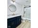Bathroom featuring a dark blue vanity, marble countertop, toilet, and glass shower with hexagon tile at 1920 E Epler E Ave, Indianapolis, IN 46227