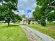 Inviting home exterior showcasing stone facade, well-manicured lawn, and a long driveway leading to the house at 1920 E Epler E Ave, Indianapolis, IN 46227
