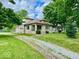 Well-kept home exterior with stone siding, a sprawling yard, and a welcoming driveway leading up to the property at 1920 E Epler E Ave, Indianapolis, IN 46227