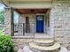 Covered front porch with a striking blue door and stone pillars at 1920 E Epler E Ave, Indianapolis, IN 46227