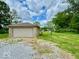 Detached garage on a spacious lot with lush green lawn and gravel driveway at 1920 E Epler E Ave, Indianapolis, IN 46227
