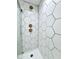 Close-up of geometric tile shower featuring brass fixtures and glass door at 1920 E Epler E Ave, Indianapolis, IN 46227