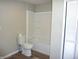 This bathroom includes vinyl plank flooring, and a white toilet and tub at 2007 Park Ave, Anderson, IN 46016