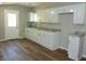 Spacious kitchen featuring white cabinets, granite countertops, and wood-look flooring at 2007 Park Ave, Anderson, IN 46016