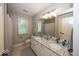 Bright bathroom featuring a double sink vanity with granite countertop and a large mirror at 21218 Carlton Ct, Noblesville, IN 46062