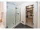 Sleek bathroom with glass-enclosed shower, shiplap, and a glimpse into the walk-in closet for added convenience at 21218 Carlton Ct, Noblesville, IN 46062