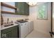 Bright laundry room features modern washer and dryer, ample cabinet space, and convenient sink with stylish countertops at 21218 Carlton Ct, Noblesville, IN 46062