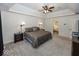 Well-lit main bedroom with a tray ceiling, large windows, soft carpet, and neutral decor, creating a relaxing space at 21218 Carlton Ct, Noblesville, IN 46062