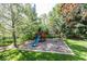 Wooden playground featuring a slide and swingset, nestled in a yard with green grass and mature trees at 21218 Carlton Ct, Noblesville, IN 46062