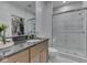 Elegant bathroom featuring granite countertops, wood cabinets, and a luxurious shower with glass doors at 222 N East St # 103, Indianapolis, IN 46204