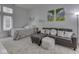 Comfortable bedroom featuring a cozy bed, leather couch with a fuzzy ottoman, and decorative wall art at 222 N East St # 103, Indianapolis, IN 46204