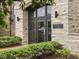 Close-up of building entrance with stone facade and manicured landscaping at 222 N East St # 103, Indianapolis, IN 46204