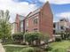 Beautiful rear exterior of the townhouse with manicured landscaping and mature trees at 222 N East St # 103, Indianapolis, IN 46204