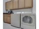 Efficient laundry room with washer, dryer, cabinets and countertop at 222 N East St # 103, Indianapolis, IN 46204