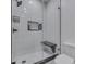 Modern shower featuring white marble tile, a built-in shower bench, and a shower caddy at 222 N East St # 103, Indianapolis, IN 46204