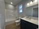 Well-lit bathroom with a modern vanity, marble countertop, and a bathtub-shower combo at 223 N Coventry Dr, Anderson, IN 46012