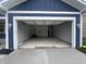 Spacious two-car garage with concrete floors and access door to home's interior at 223 N Coventry Dr, Anderson, IN 46012