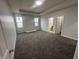 Bright main bedroom with soft gray carpet and multiple bright windows at 223 N Coventry Dr, Anderson, IN 46012