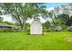 Large backyard shed surrounded by well-kept grass and mature trees in this peaceful property at 3027 Griffa Ave, Columbus, IN 47203