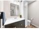 Bathroom featuring updated vanity, mirror and lighting and a view to the toilet and linen storage at 3027 Griffa Ave, Columbus, IN 47203