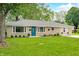 Charming one-story home featuring a blue front door and well-maintained front lawn at 3027 Griffa Ave, Columbus, IN 47203