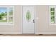 A bright, white front door with an oval glass window stands out, framed by two windows at 3027 Griffa Ave, Columbus, IN 47203