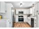 Modern kitchen with stainless steel appliances, white cabinets, and hardwood floors at 3027 Griffa Ave, Columbus, IN 47203