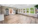 Bright sunroom with large windows, stone accent wall, and vinyl flooring at 3027 Griffa Ave, Columbus, IN 47203