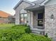 Inviting entryway of brick home featuring a decorative door, green shrubbery, and well-maintained landscaping at 3037 Ash Way, Lapel, IN 46051
