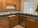 Kitchen showcasing wooden cabinets, stainless steel dishwasher and faucet at 3208 Wellington Ave, Indianapolis, IN 46226