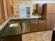 Kitchen featuring wooden cabinets, a stainless steel dishwasher, and green countertops at 3208 Wellington Ave, Indianapolis, IN 46226