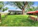 Expansive backyard with mature trees, lush grass, and a charming swing set at 3552 N Talley Rd, Columbus, IN 47203