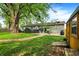 Spacious backyard with green lawn, mature tree, patio, and shed, ideal for outdoor living and entertaining at 3552 N Talley Rd, Columbus, IN 47203