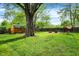 Large backyard with a fire pit area, shed, swing sets, and mature trees at 3552 N Talley Rd, Columbus, IN 47203