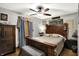 Charming bedroom with wood-framed bed, ceiling fan, and decorative curtains at 3552 N Talley Rd, Columbus, IN 47203