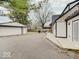 A detached garage with a paved driveway to the backyard's entertaining area with outdoor furniture at 3659 Watson Rd, Indianapolis, IN 46205