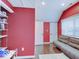 Bright bedroom featuring red walls, hardwood floors, and a comfortable gray sofa at 3659 Watson Rd, Indianapolis, IN 46205