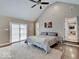 Large primary bedroom with vaulted ceiling, hard wood floors, and sliding glass door to patio at 3659 Watson Rd, Indianapolis, IN 46205