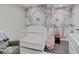 Charming Bedroom with floral wallpaper, a white crib, and a comfortable rocking chair at 3659 Watson Rd, Indianapolis, IN 46205
