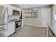 Kitchen area featuring stainless steel appliances, grey tile flooring, white subway tile backsplash and floating picture shelves at 3659 Watson Rd, Indianapolis, IN 46205