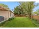 Large backyard with a lawn, a wood fence, the side of the house and mature trees at 3754 Smallwood W Ln, Indianapolis, IN 46214