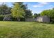 Well-maintained backyard with a storage shed, lush green lawn, and mature trees at 3904 Haverhill Dr, Indianapolis, IN 46240